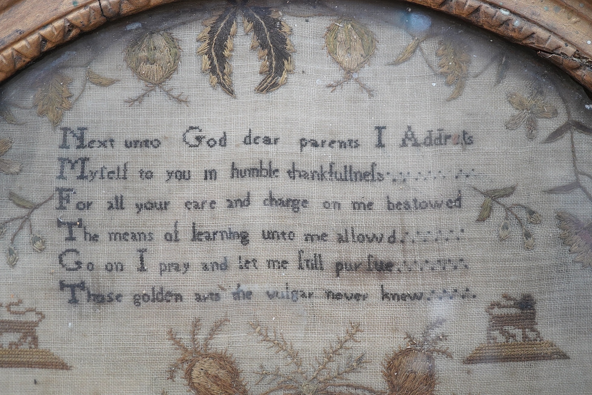 An unusual charming circular gilt framed sampler, by Elizabeth Hughes, aged 11 years, dated 1795, worked in fine wools with a prayer verse at the top and an embroidered floral border with motifs of lions, stags, flowers,